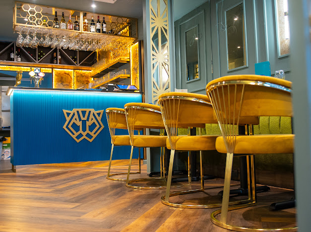 Stylish ZOYA GRILL & LOUNGE with golden chairs, perfect for upscale events and gatherings.