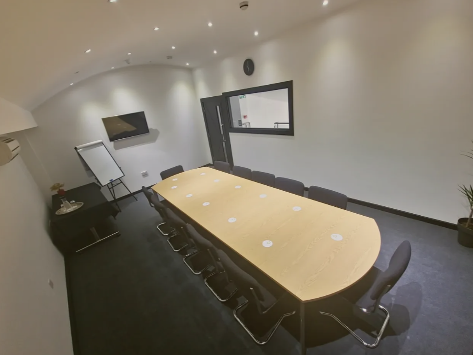 Modern London conference room with wooden table, ideal for professional meetings and events.