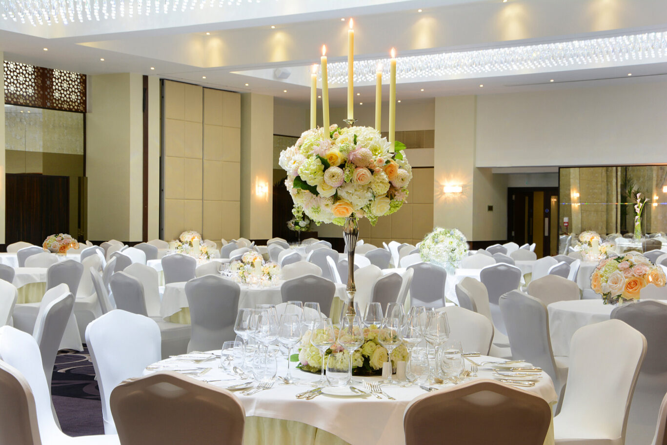 Elegant Grand Ballroom with floral centerpieces, ideal for weddings and corporate events.