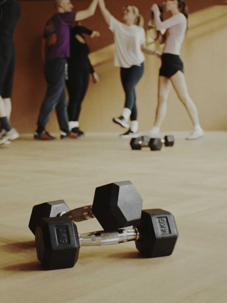Dynamic fitness event at Loom Club with participants using dumbbells for strength training.