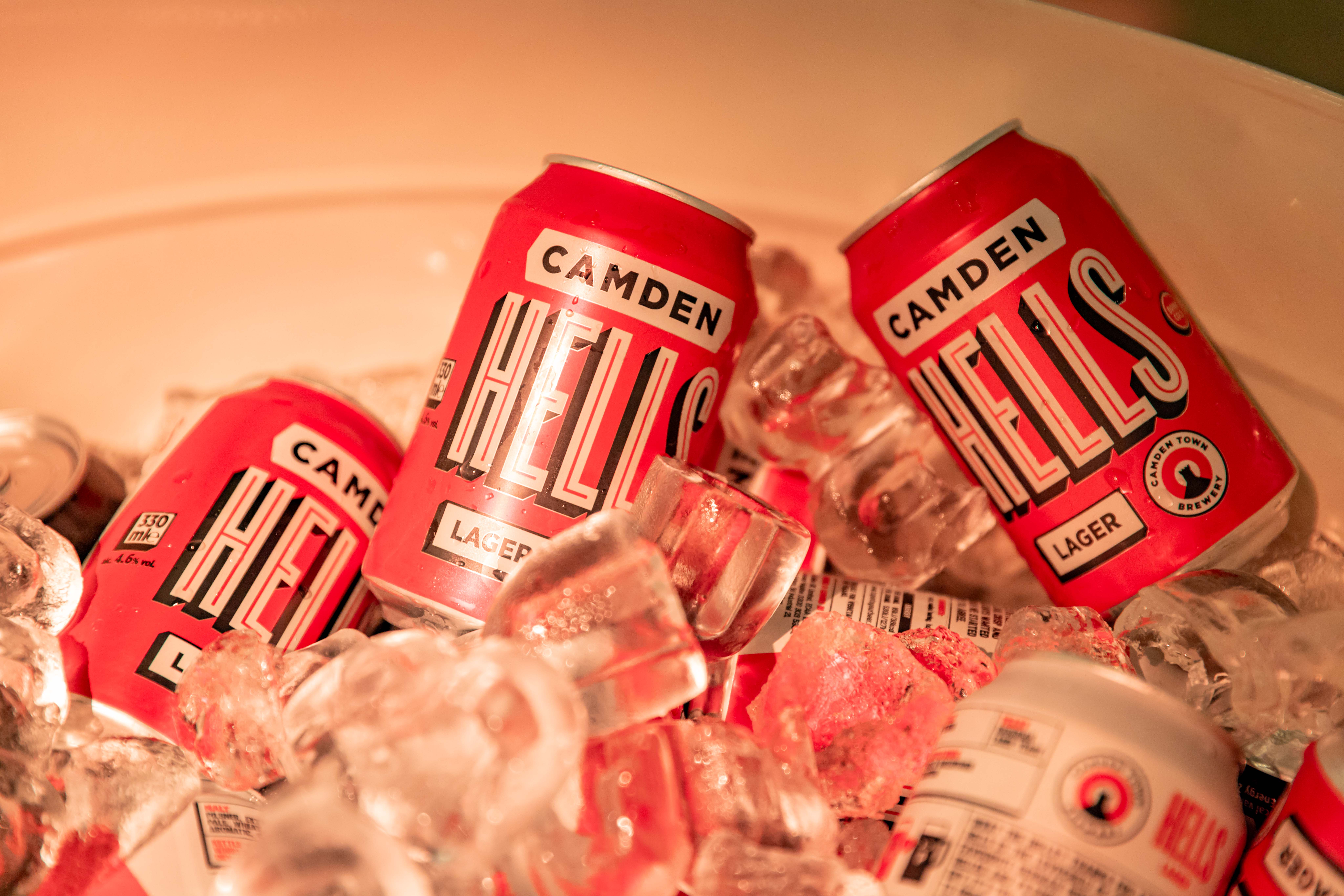 Camden Hells lager cans in ice for vibrant event refreshment station.