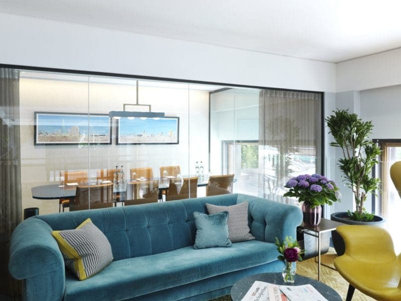 Modern meeting space at The Athenaeum Hotel with teal sofa, ideal for events and gatherings.