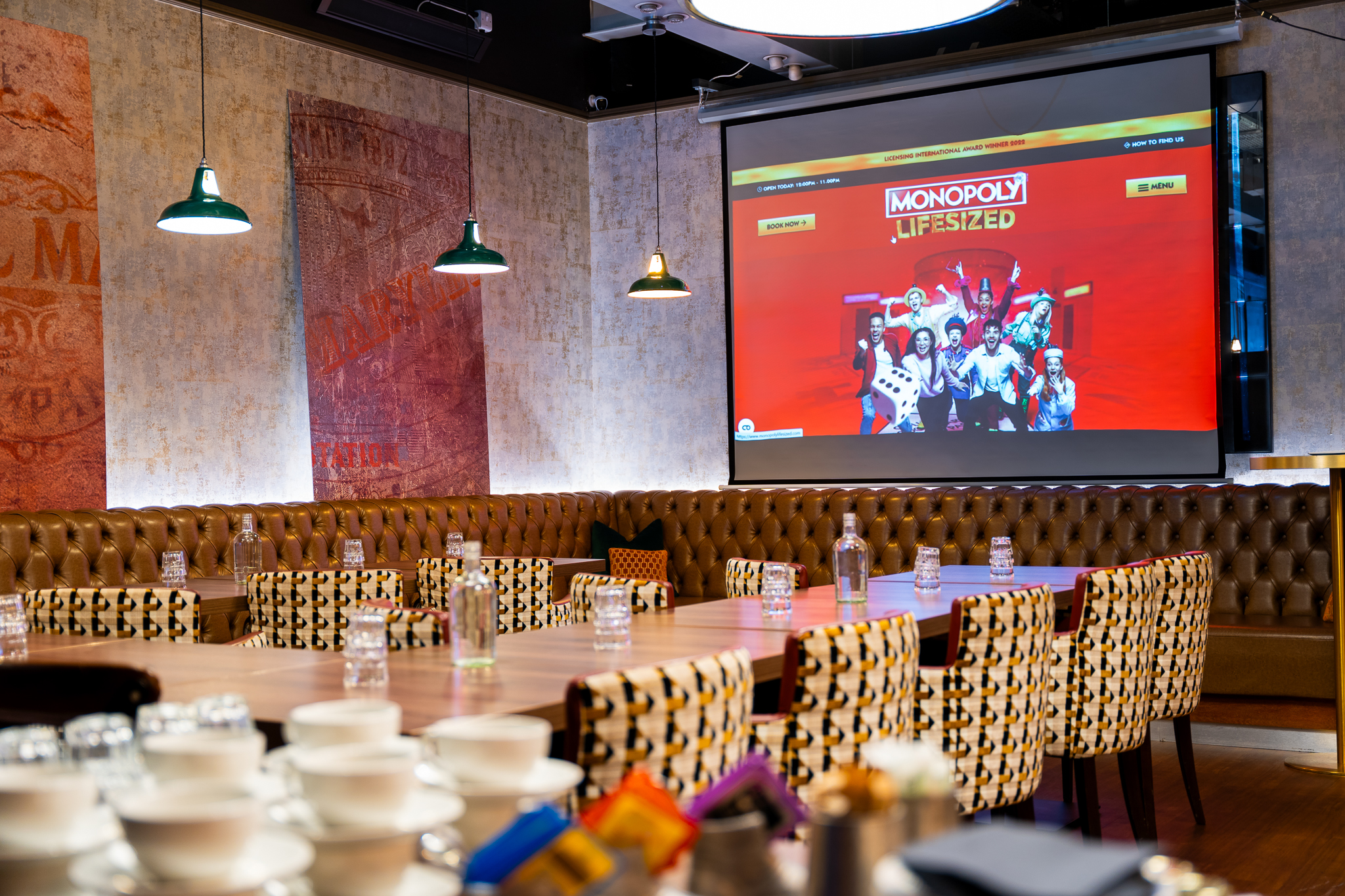 Semi-private hire event space at Top Hat Restaurant with large screen and stylish decor.