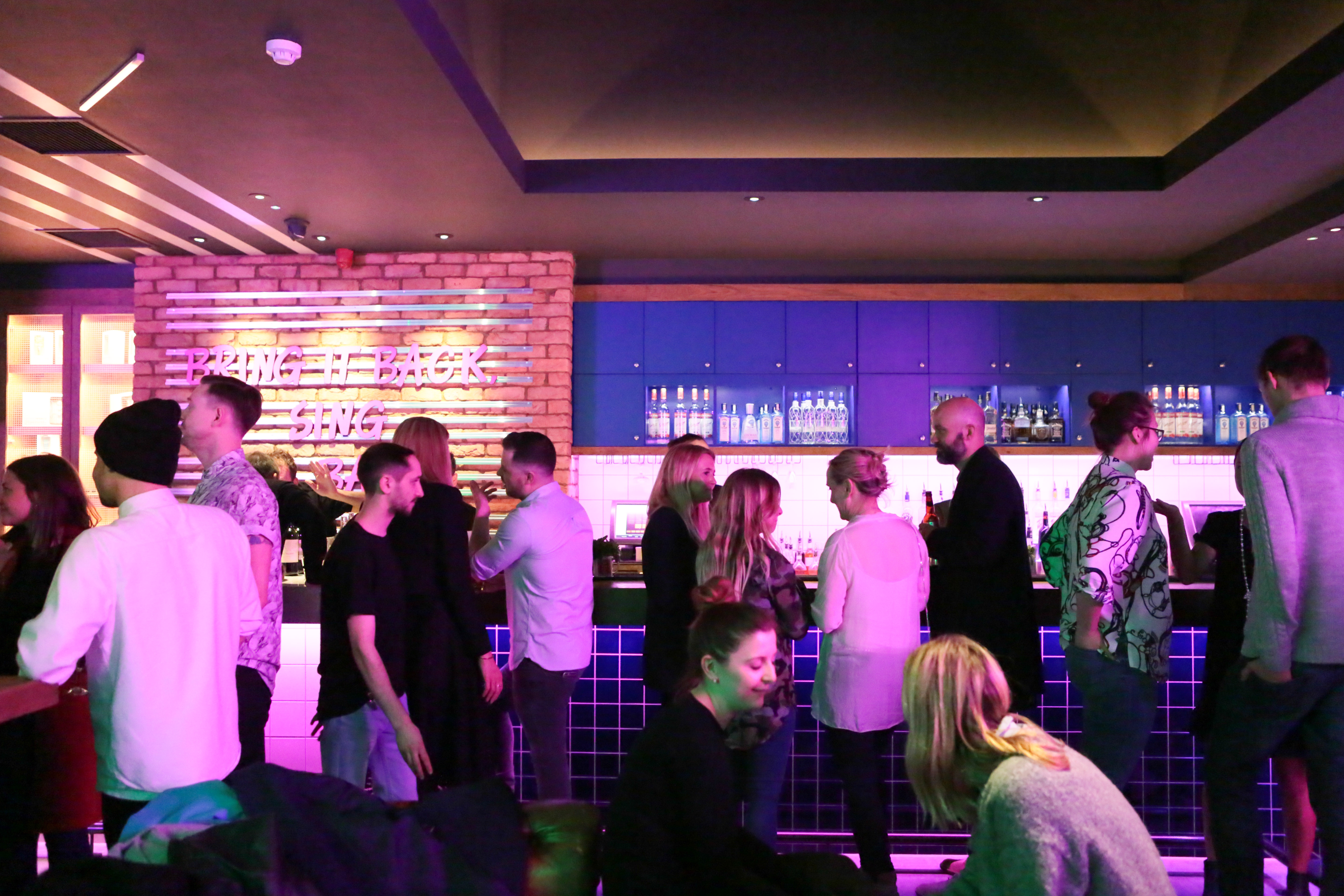Vibrant networking event at Lucky Voice Islington with colorful lighting and stylish decor.