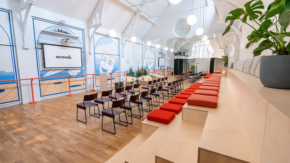 Modern WeWork event space with tiered seating, ideal for workshops and networking.