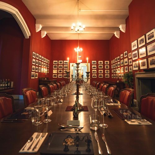 Private dining room with red walls, ideal for intimate meetings and dinner events.