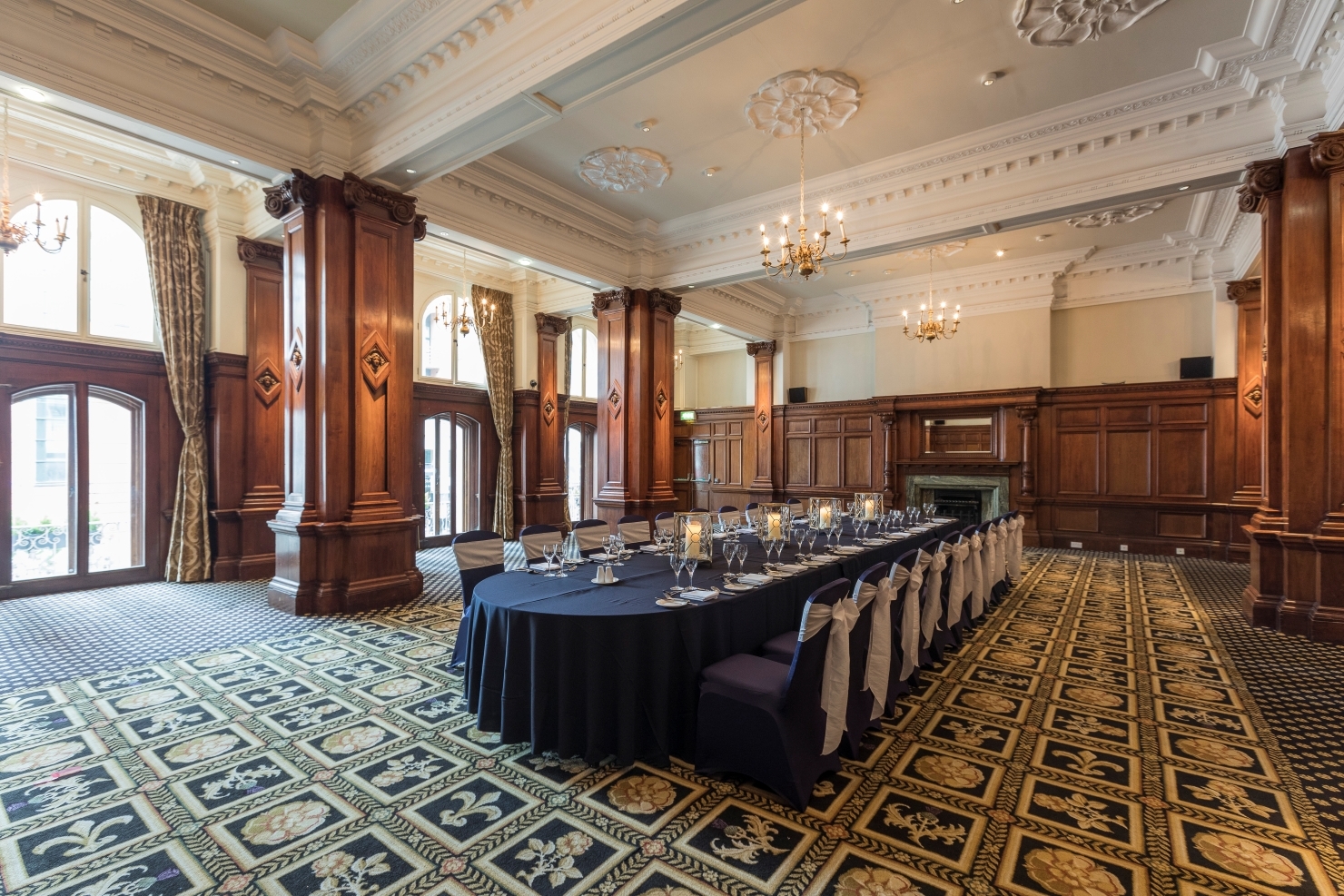 Stanley suite at The Midland Hotel: elegant meeting space with wooden paneling and chandeliers.