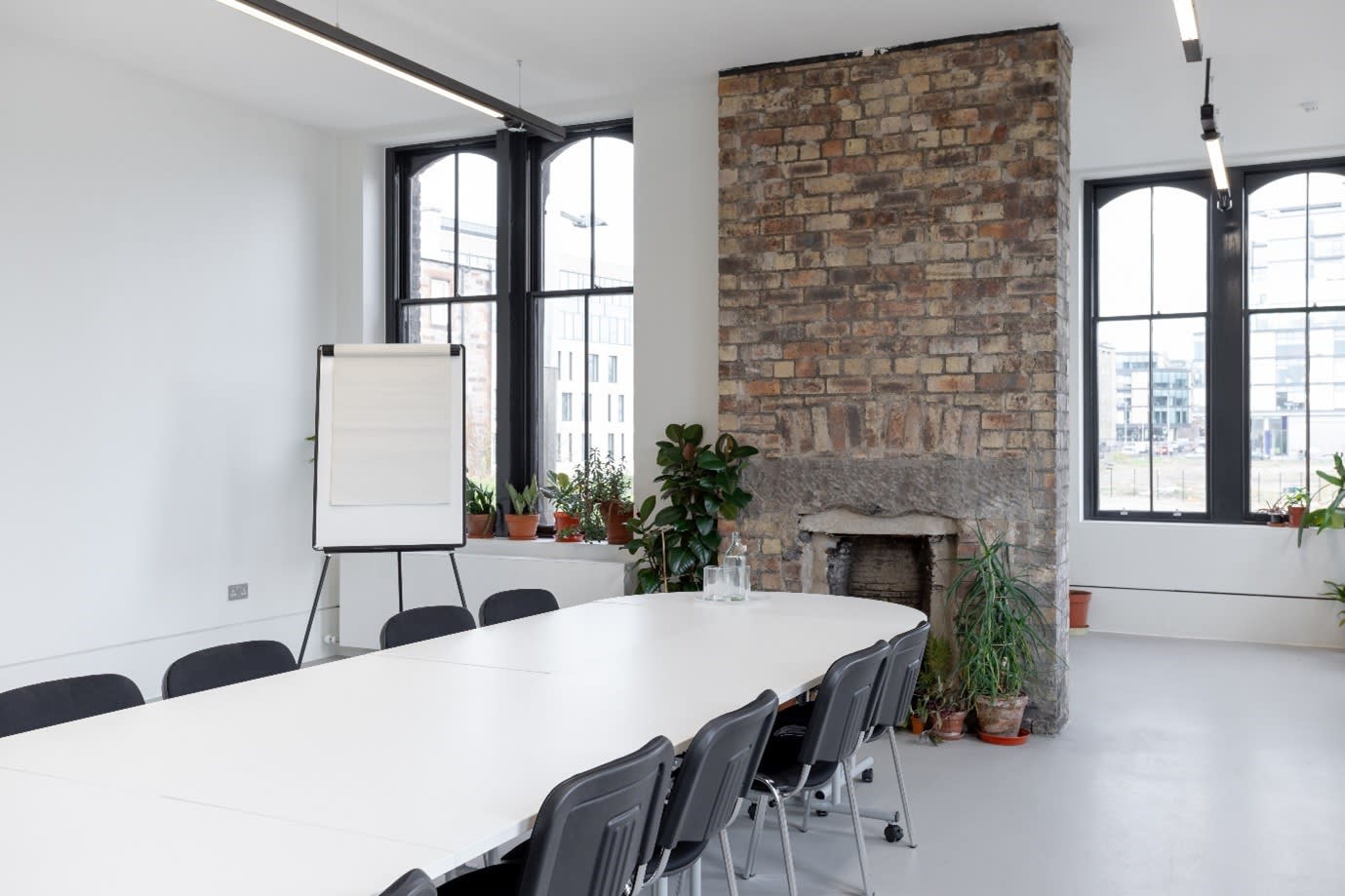 Modern meeting space with white table and black chairs at Edinburgh Printmakers.