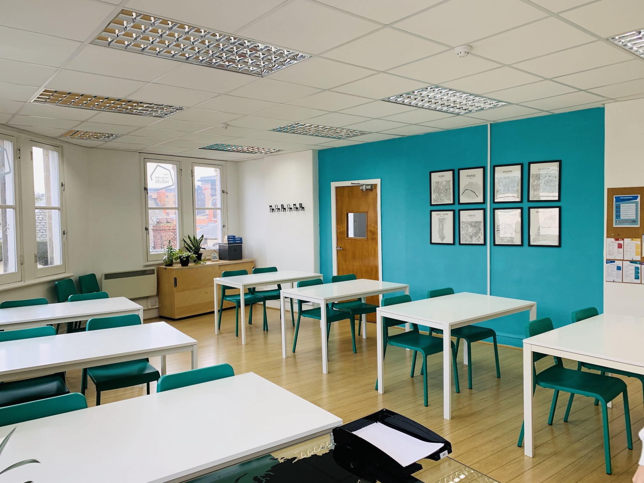 Classroom at ACE Language School with turquoise wall, ideal for workshops and training.