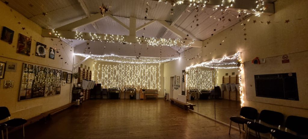 "Cozy event space with fairy lights at Signol Community Centre for gatherings and workshops."