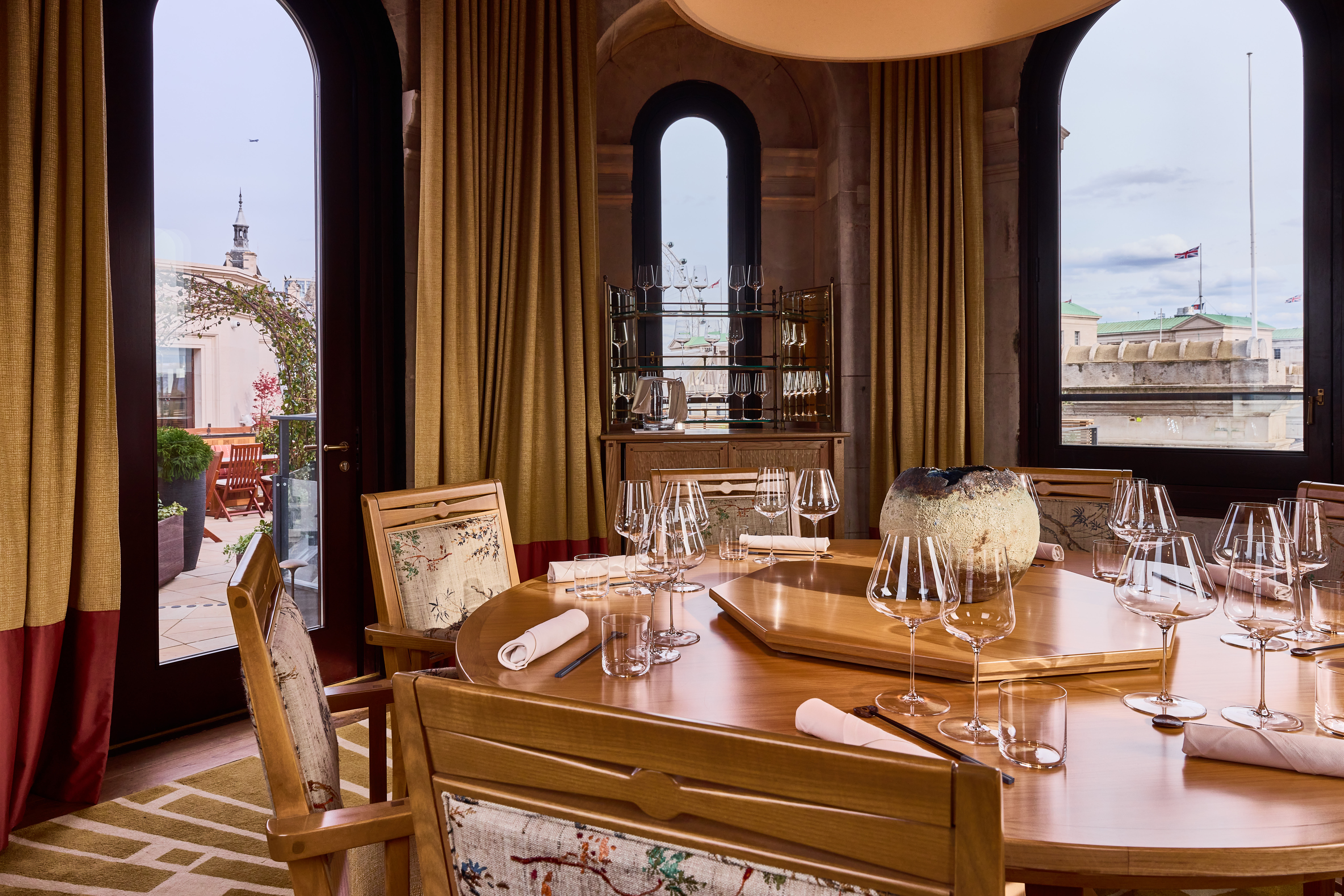 Elegant meeting space with wooden table, fine glassware for exclusive dining events.