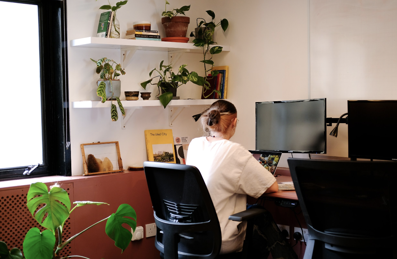 Modern coworking private office with dual monitors and natural light for productive meetings.