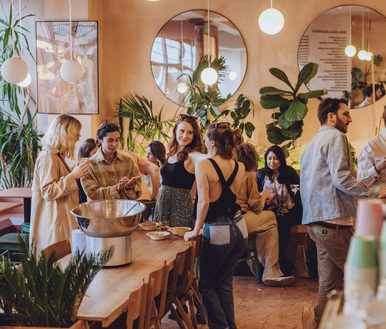 Vibrant networking event in stylish coworking space with lush greenery and modern decor.