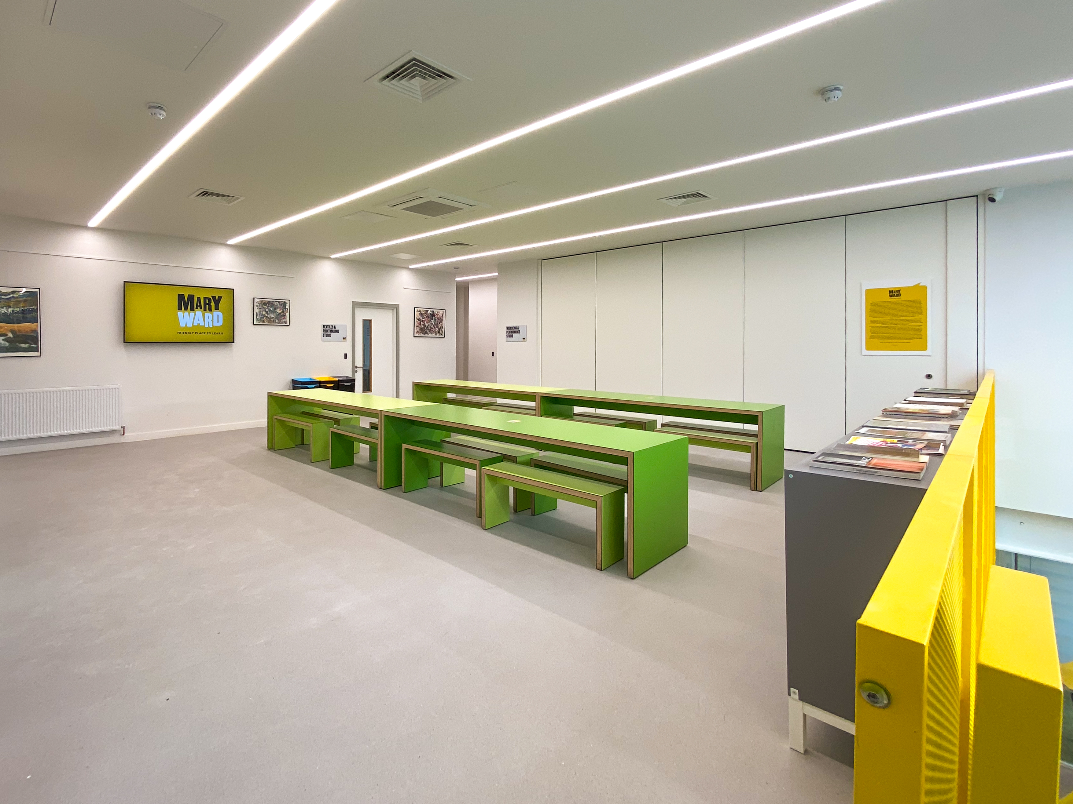 Modern meeting space with green furniture, ideal for workshops and team-building events.