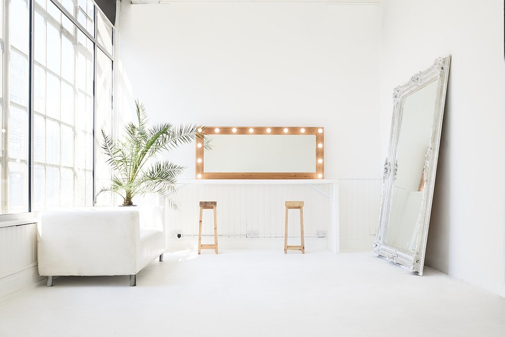 Bright minimalist event space with large windows, ideal for beauty events and workshops.