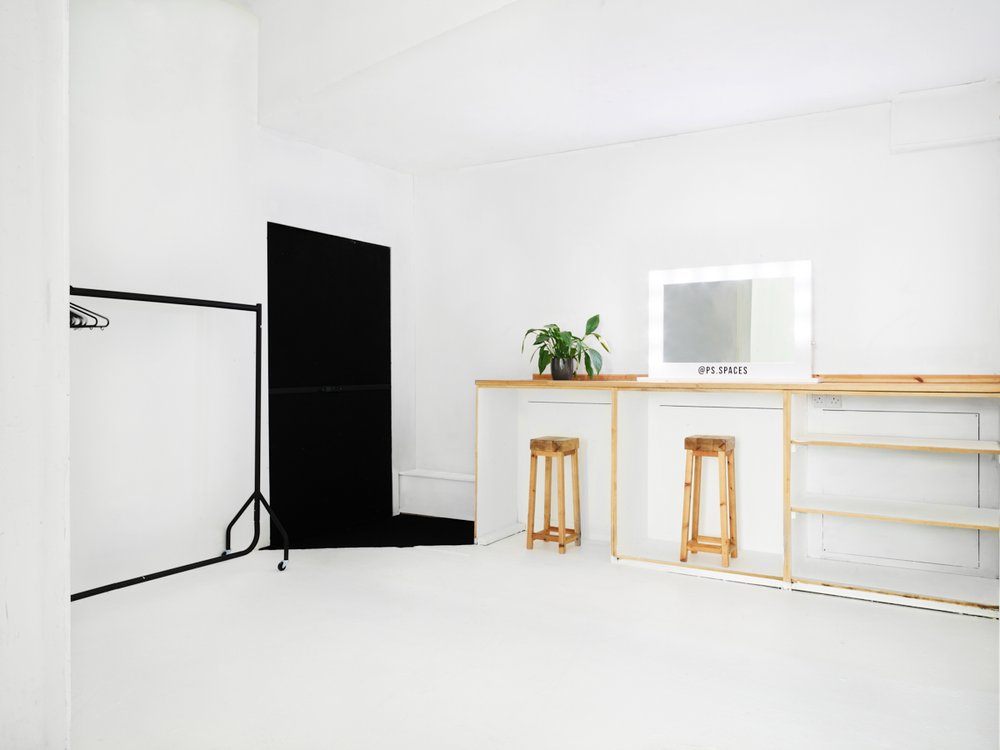 Minimalist event space with white backdrop for versatile photo shoots and workshops.