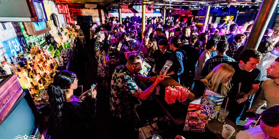 Cocktail bar at Embargo Republica, vibrant atmosphere for networking and entertainment.