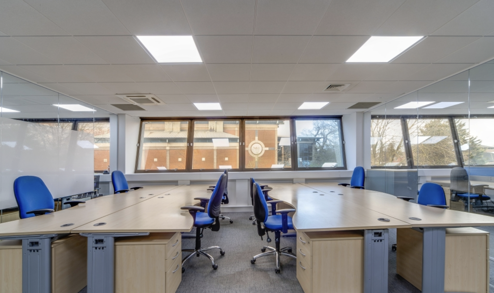 Modern meeting space with spacious tables and ergonomic blue chairs for corporate events.