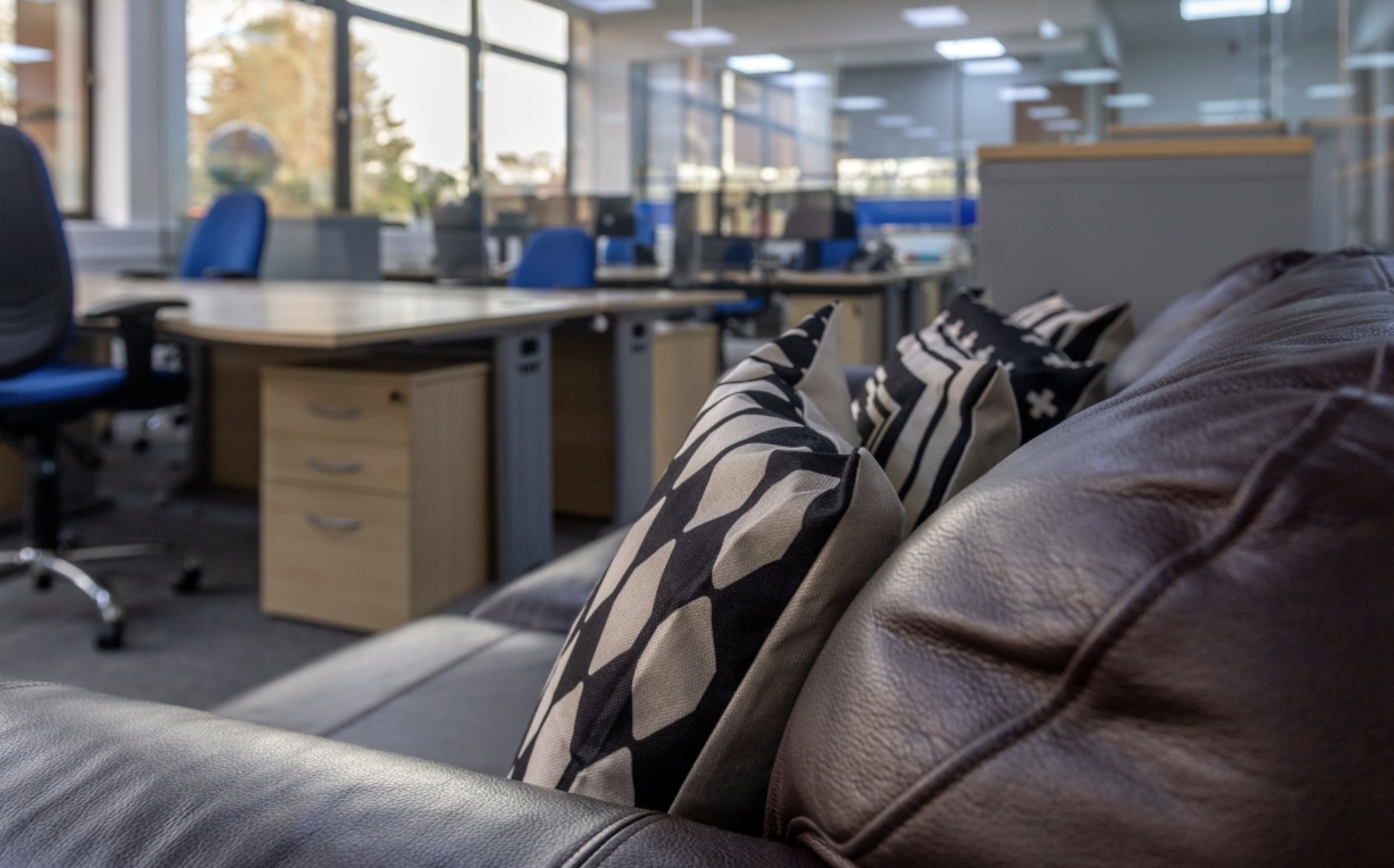 Modern office space with leather couch, perfect for collaboration and workshops.