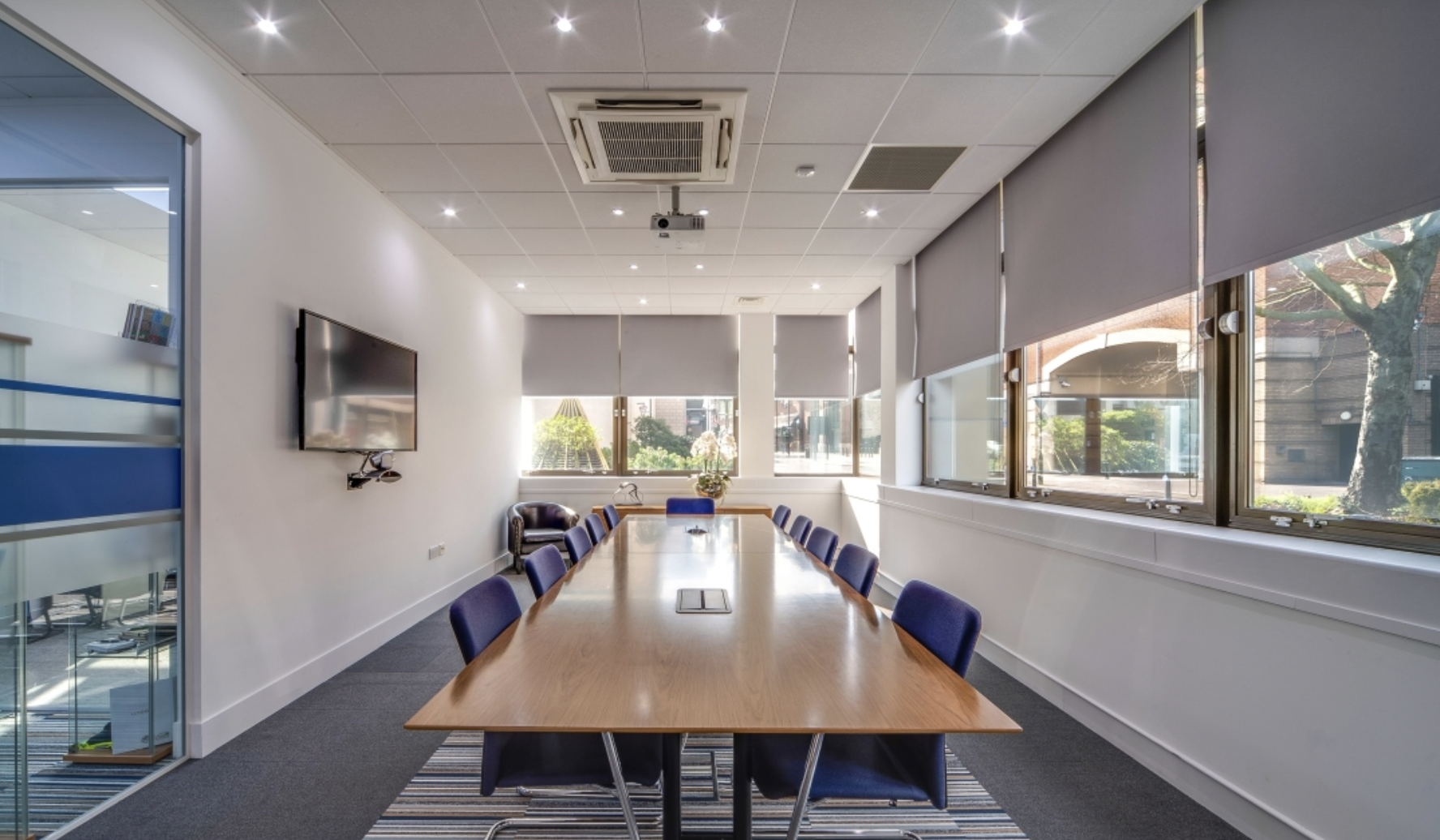Modern conference room with wooden table and blue chairs for effective meetings.