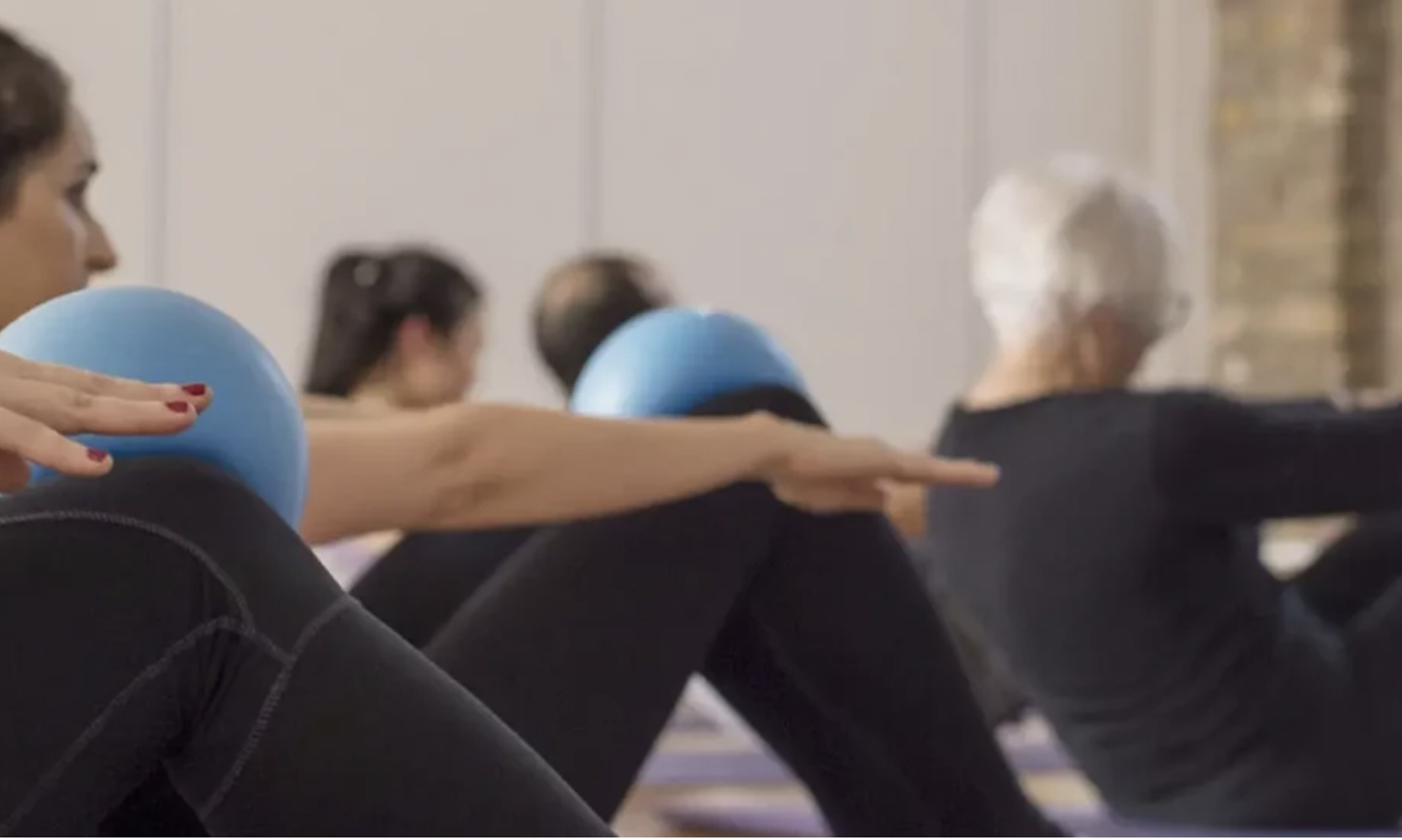 Group fitness class with exercise balls in triyoga Treatment Rooms for corporate wellness events.