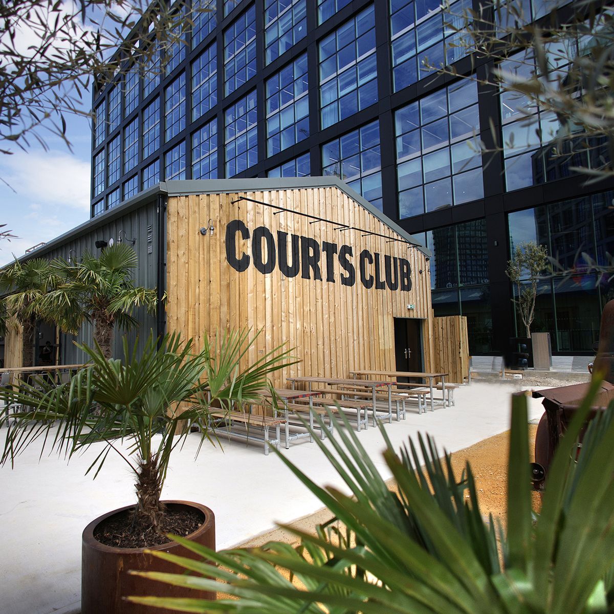 Courts Club outdoor venue with modern wooden facade for events and gatherings