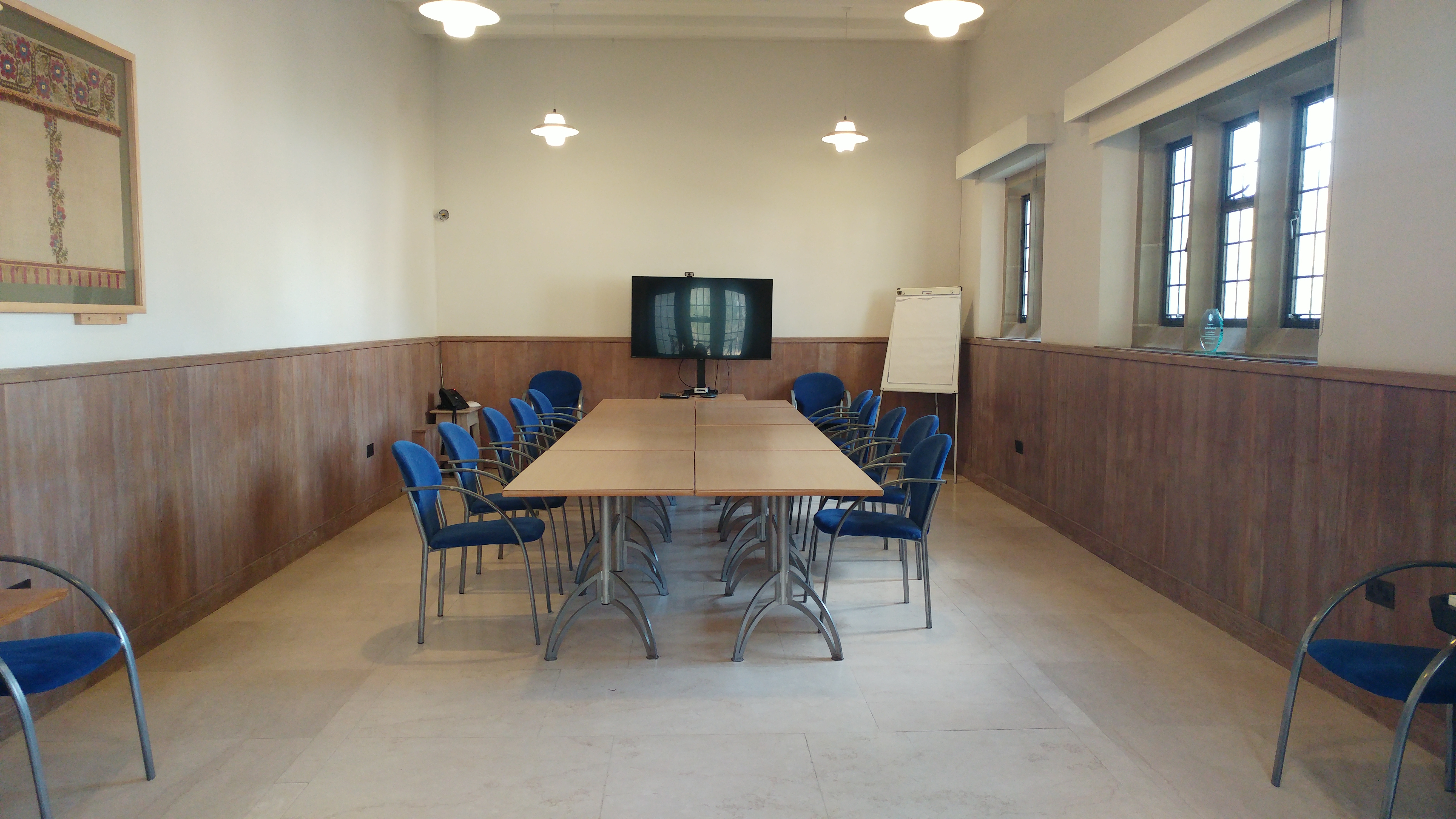Chapter House in Bradford Cathedral, bright meeting room with long table and blue chairs.