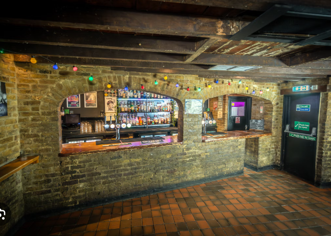 Cozy bar with exposed brick, ideal for casual networking events and celebrations.