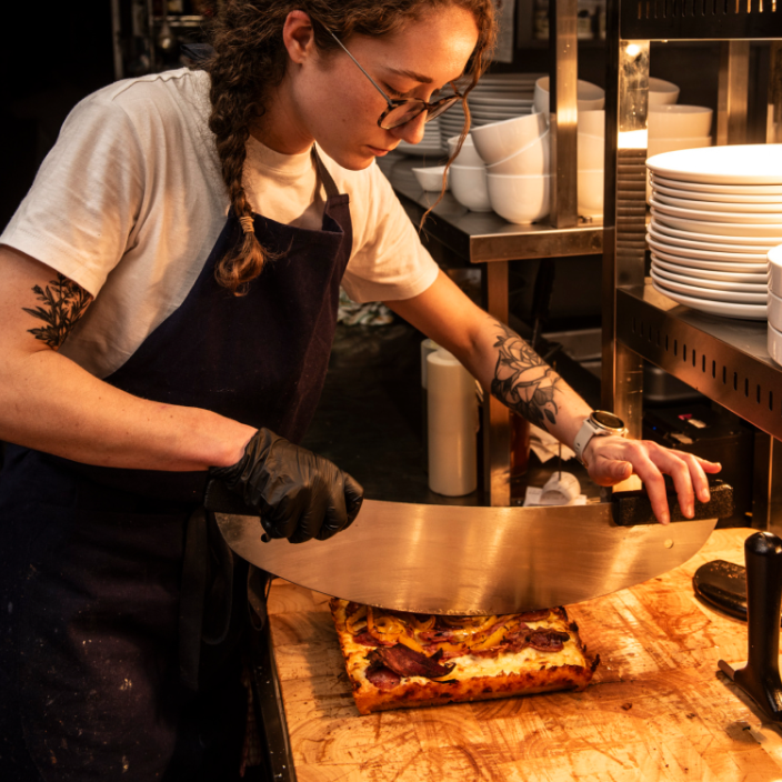 Dedicated kitchen staff member preparing dishes at Parts & Labor for events.