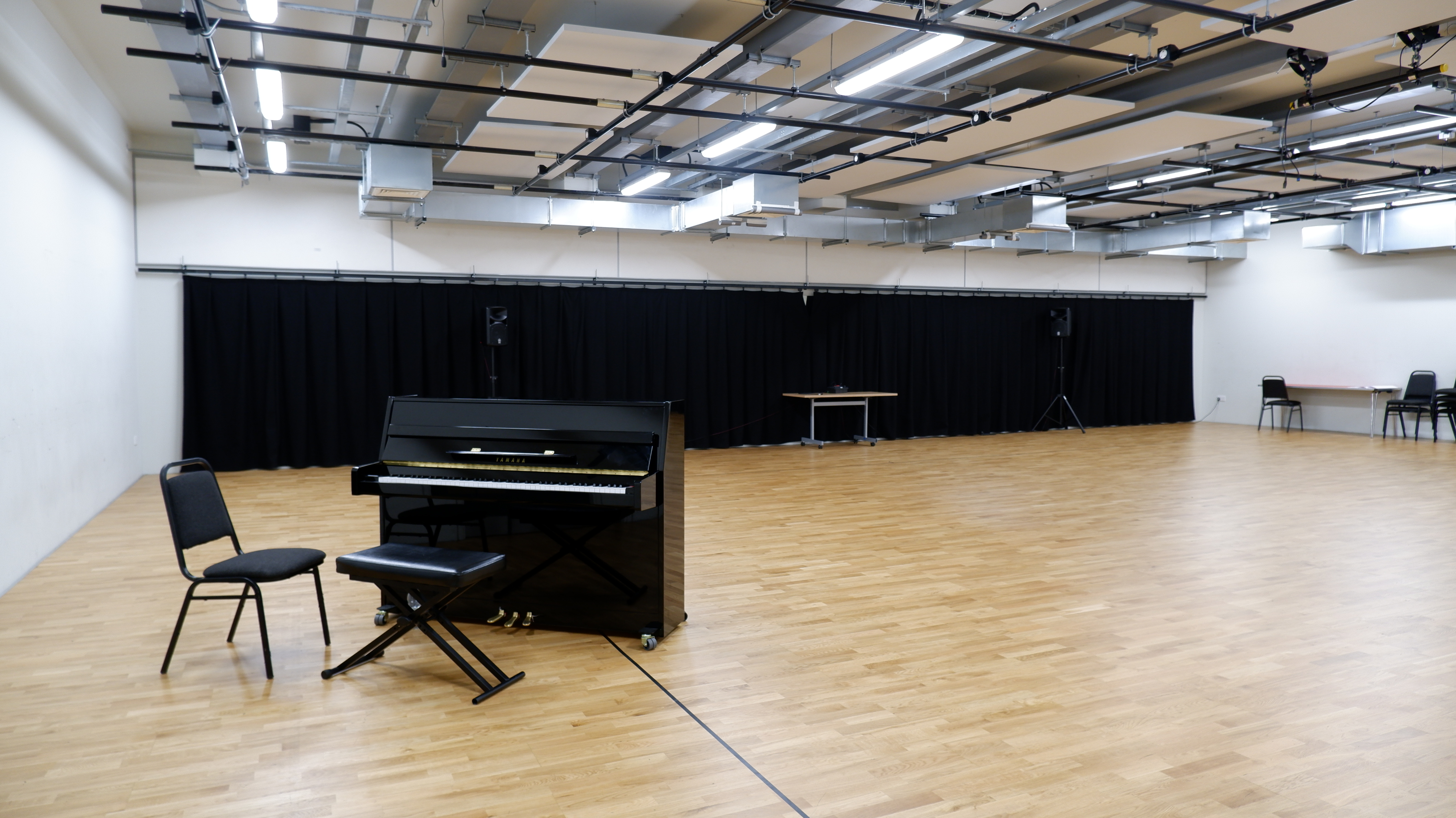 Versatile rehearsal studio with polished wooden floor, ideal for events and performances.