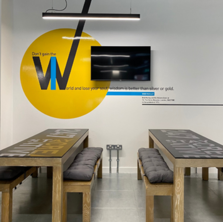 Modern meeting space with yellow wall, ideal for workshops and brainstorming sessions.