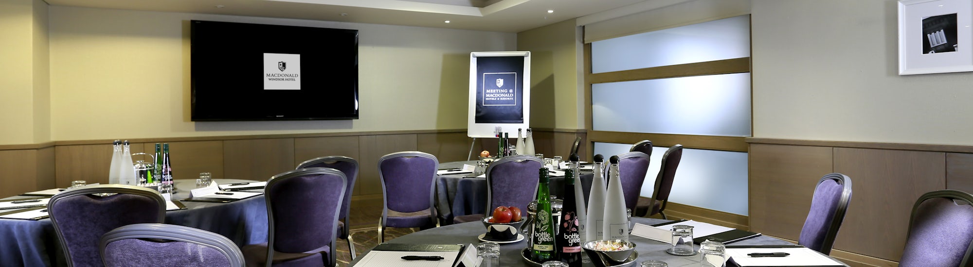 Elegant meeting room at Macdonald Windsor Hotel for corporate events with AV equipment.