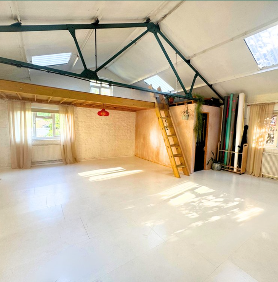 Versatile event space with high ceilings and natural light for workshops and gatherings.