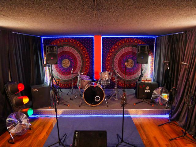 Vibrant performance space in DB Music London with drum set for live events.