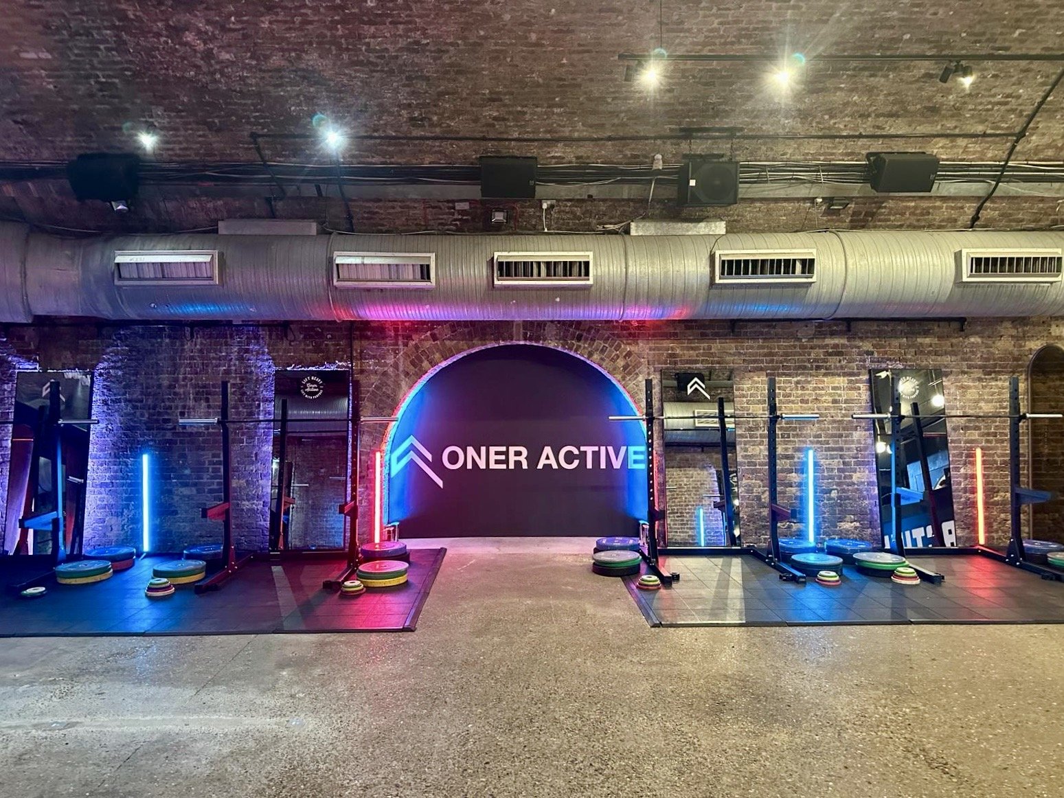 Modern fitness event space with neon lighting at 83 Rivington Street for wellness retreats.