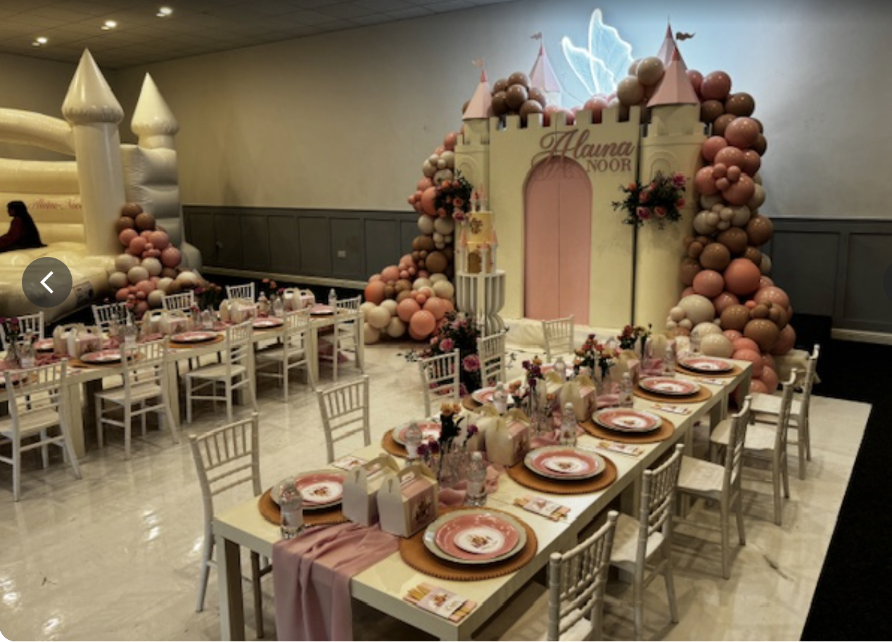Children's celebration venue with whimsical castle backdrop and pastel balloons.