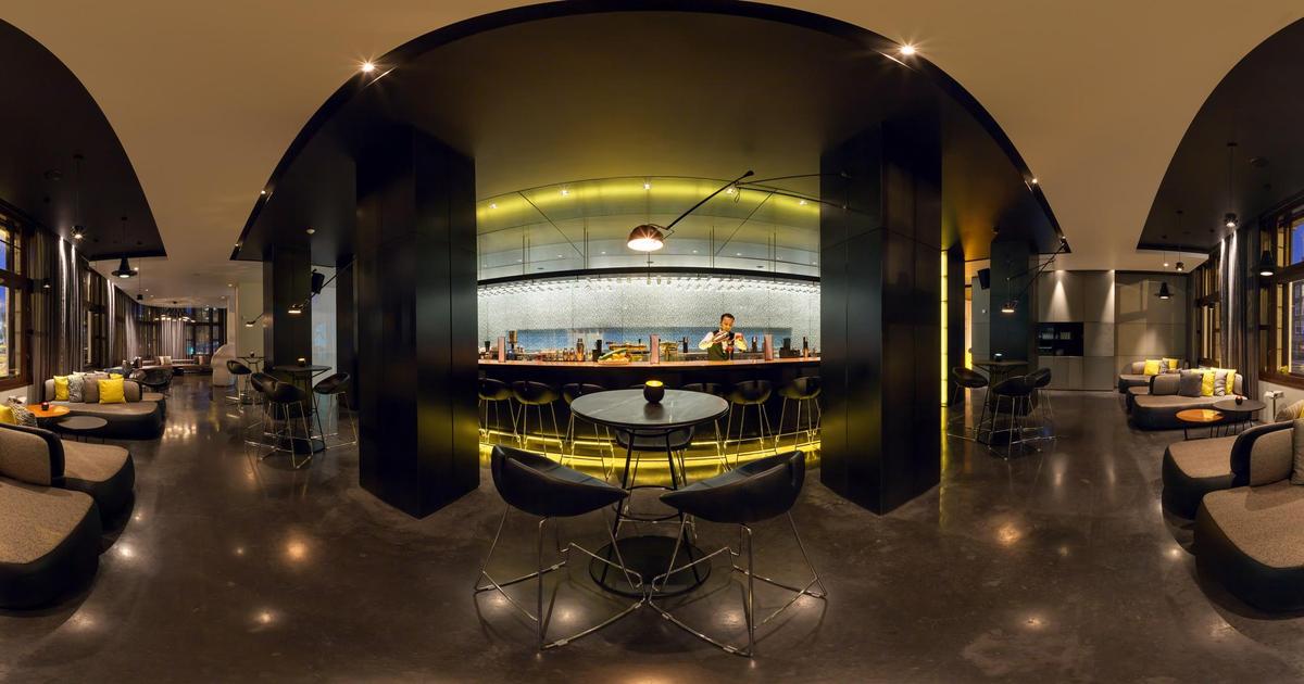 Private dining room at art'otel Amsterdam with modern bar, ideal for networking events.