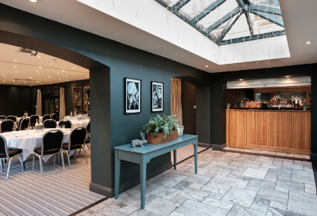 Elegant conference space at The Manor House Hotel with round tables and natural light.