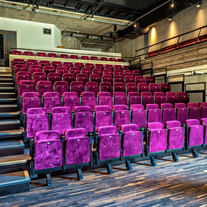 Cornerstone Room at Square Chapel: vibrant purple seating in a modern auditorium for events.