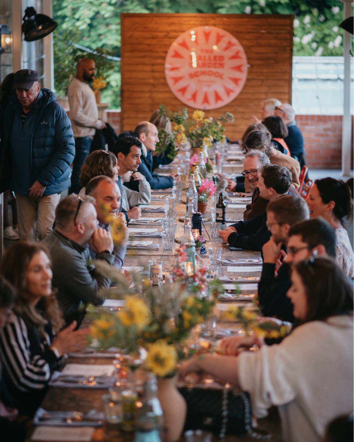 Long table with floral centerpieces in The Walled Garden, ideal for networking events.