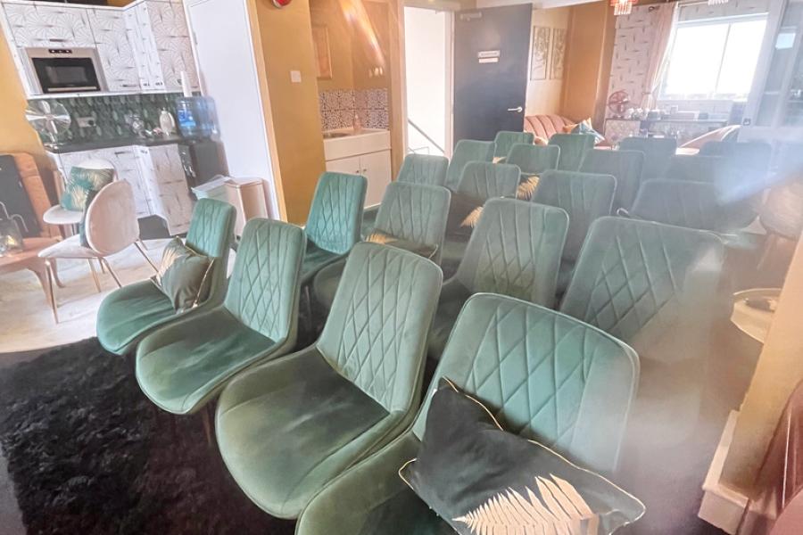 Cozy meeting space with plush green chairs, ideal for workshops and brainstorming sessions.