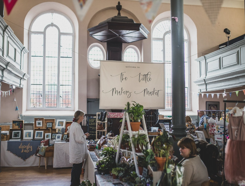 Vibrant artisan fair at Unitarian Meeting House with natural light and local crafts.