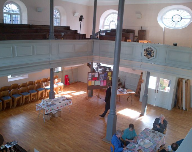 Versatile event space in Unitarian Meeting House with wooden floor, ideal for gatherings.