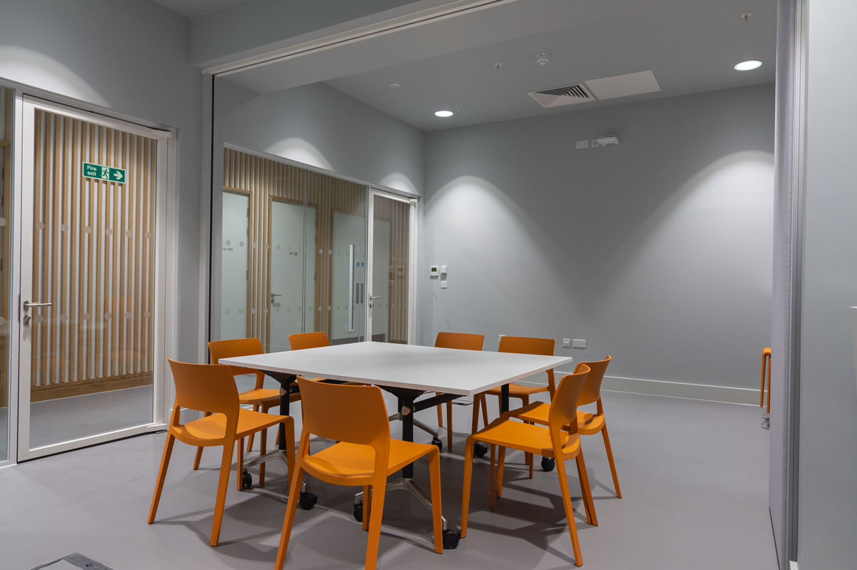 Modern meeting room with orange chairs, ideal for brainstorming and workshops.