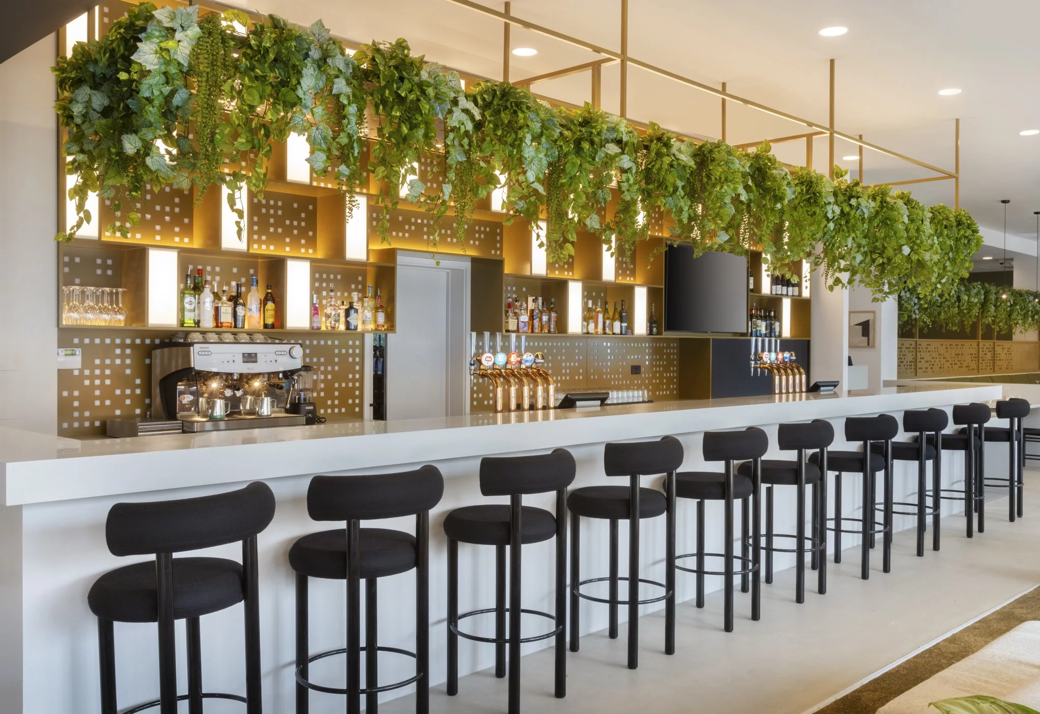 Modern bar area with white countertop and greenery at Leonardo Hotel Manchester Central.