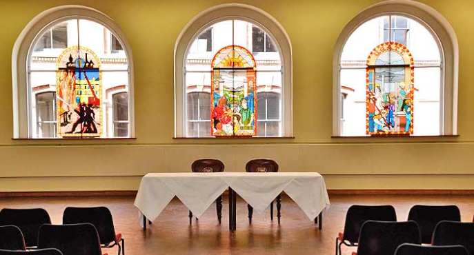 Large Hall in Mechanics Conference Centre with stained glass windows, ideal for events.