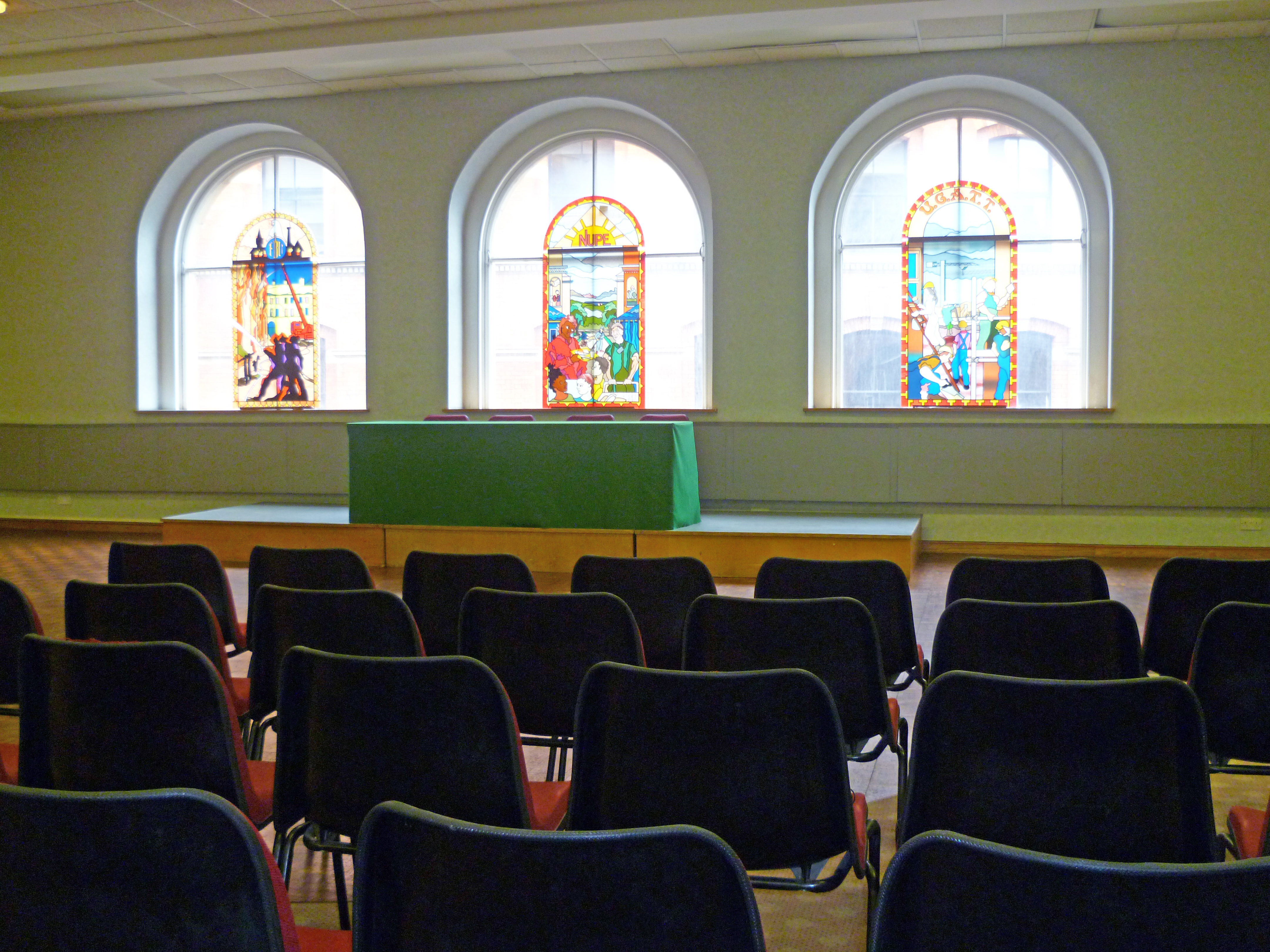 Large Hall at Mechanics Conference Centre with stained glass windows for meetings and presentations.