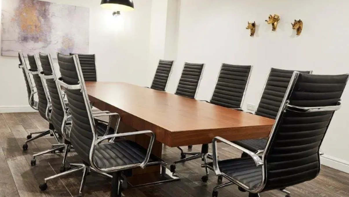 Modern conference room at Grosvenor House St Pauls with sleek wooden table, ideal for meetings.