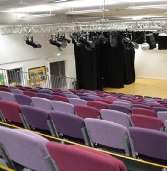 Theatre auditorium with tiered seating, perfect for presentations and performances.