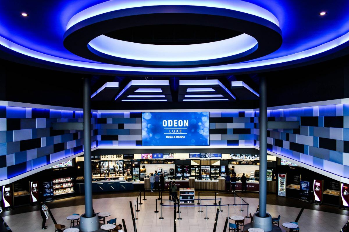 Modern cinema lobby at ODEON LUXE Birmingham with vibrant blue lighting for events.